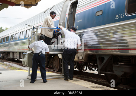 Signora usando un portatile di servoscala a bordo di un treno Amtrak a DeLand Station Florida USA Foto Stock