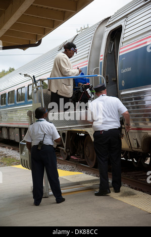 Signora usando un portatile di servoscala a bordo di un treno Amtrak a DeLand Station Florida USA Foto Stock