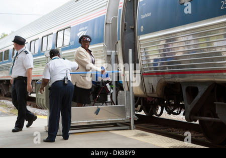 Signora usando un portatile di servoscala a bordo di un treno Amtrak a DeLand Station Florida USA Foto Stock