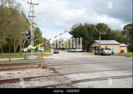 Passaggio a livello barriera in posizione chiusa con il treno in avvicinamento DeLand Florida USA Foto Stock