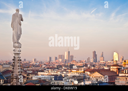 Milano, fine 2013 nuovo skyline panoramico al tramonto. Uno dei religiosi statue del Duomo è rivolta a nord di nuova generazione Foto Stock