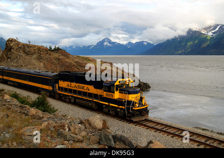 Treno sul braccio Turnagain in Alaska in direzione di ancoraggio con nuvole. Foto Stock