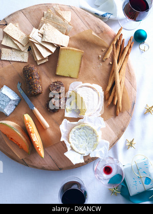 Un vassoio di formaggi con pane e roccia melone sulla tavola decorati Foto Stock