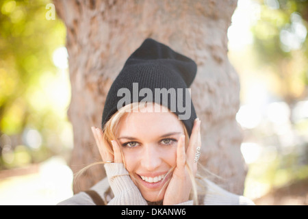 Giovane donna con le mani sul viso in posizione di parcheggio Foto Stock