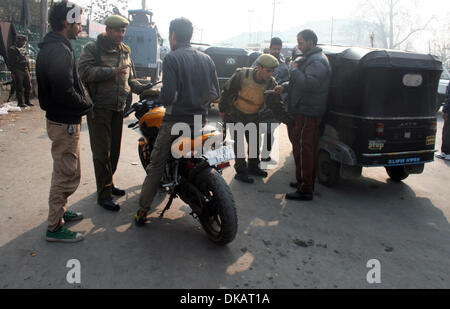 Srinagar, Indiano Kashmir amministrato del04 dicembre 2013 poliziotti indiano frisks durante un high security alert in srinagar ,la capitale estiva di indiano Kashmir amministrato. Un elevato livello di sicurezza è stata intensificata in srinagar dopo il funzionario di polizia è stato ucciso e due suoi colleghi feriti mentre erano di pattuglia un mercato in chadoora città nel distretto di budgam 25km (16 miglia) da srinagar. (Sofi Suhail/ Alamy Live News) Foto Stock