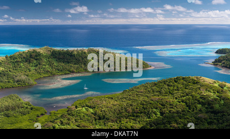 Isola tropicale, yacht che sono ancorate al largo di villaggio di Lomati. Passare attraverso il corallo a laguna, a destra del telaio. Matuku, Lau, Isole Figi Foto Stock