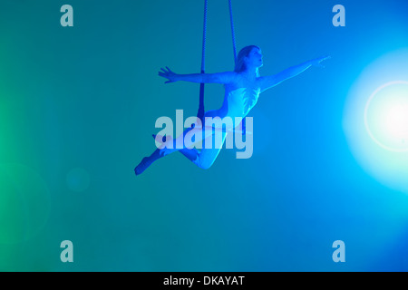 Giovane donna su trapezio Foto Stock