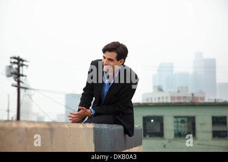 Felice giovane uomo sul tetto della città Foto Stock