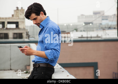 Ansioso giovane uomo sul tetto della città Foto Stock