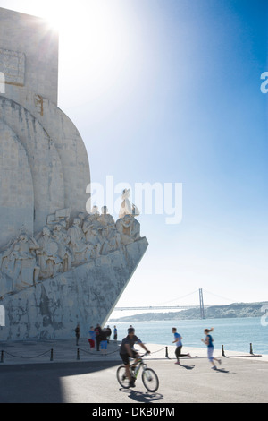 Cicli di uomo passato il Monumento alle Scoperte, Belem, Lisbona, Portogallo Foto Stock