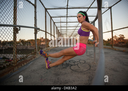 Femmina stretching pareggiatore sul marciapiede Foto Stock