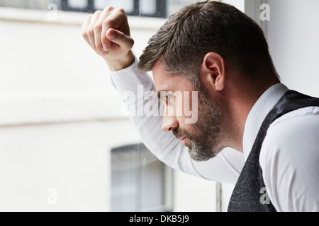 Ritratto di imprenditore guardando fuori della finestra Foto Stock