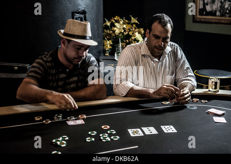 Metà uomini adulti giocando a poker e bere cocktail Foto Stock