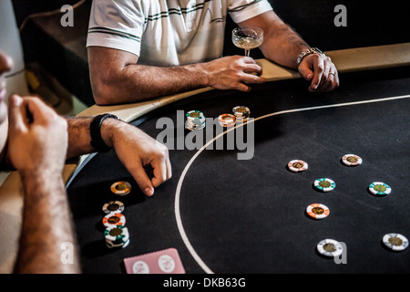 Metà uomini adulti giocando a poker e bere cocktail Foto Stock