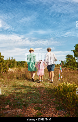 Famiglia camminando su erba, vista posteriore, Eggergrund, Svezia Foto Stock