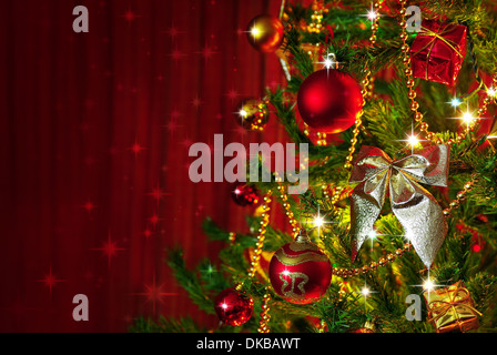 Dettaglio di un albero di natale accanto alla finestra di rosso le tende con spazio di copia Foto Stock