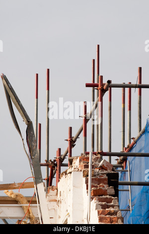 Ponteggio su un parziale demolizione del muro contro un cielo blu Foto Stock