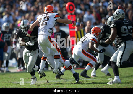 16 ottobre 2011 - Oakland, la California, Stati Uniti - Browns quarterback Colt McCoy (12) rilascia un pass sotto pressione da predatori linebacker Kamerion Wimbley (96) durante il gioco di NFL tra i Cleveland Browns e Oakland Raiders a O.co Coliseum di Oakland, CA. I raider tenuto su per un 24-17 Win. (Credito Immagine: © Matt Cohen/Southcreek/ZUMAPRESS.com) Foto Stock