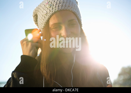 Ritratto di giovane donna che indossa gli auricolari per ascoltare musica Foto Stock