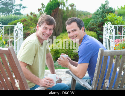 Due maschi adulti amici rilassarsi in giardino Foto Stock