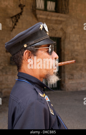 Cuba - sigari cubani guardia ufficiale di fumare un sigaro, Plaza de Armas, Havana, Cuba Caraibi Foto Stock