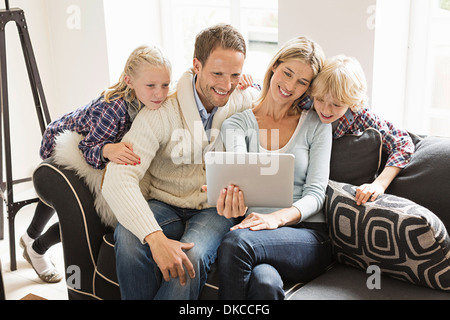 I genitori con due bambini con tavoletta digitale Foto Stock