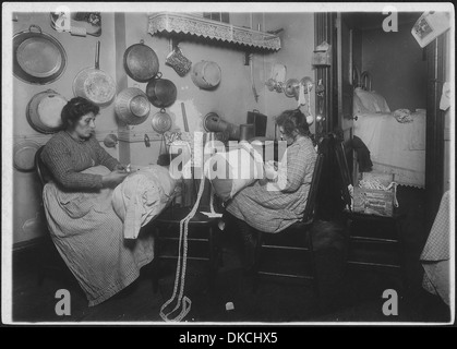 La sig.ra Palontona e 13 anni figlia, lavorando sul cuscino-pizzi in cucina sporchi di loro tenement home. Essi sono stati... 523503 Foto Stock