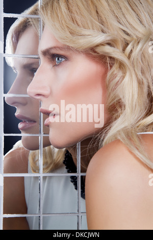 Ritratto di donna in posa contro lo specchio Foto Stock