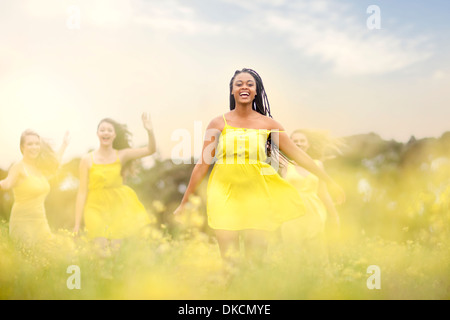 Le ragazze in giallo ballando sul prato Foto Stock