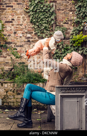 Madre di gettare il bambino in aria Foto Stock