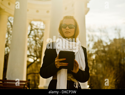 Donna che mantiene digitale compressa dal padiglione di pietra Foto Stock