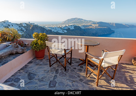 Tavoli e sedie pronto per i clienti su un balcone a Fira, Santorini, Grecia Foto Stock