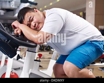 Il sovrappeso giovane uomo che lavora in palestra Foto Stock