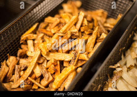 Golden brown incendi francesi nella friggitrice, cucinata fresca chips pronti a servire. Foto Stock