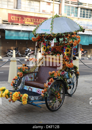 Si tratta di una foto di un bellissimo decorato rickshaw con fiori in Penang in Malaysia. Vi è un ombrellone troppo Foto Stock