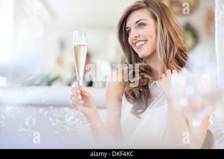 Giovane donna tenendo un bicchiere di champagne Foto Stock