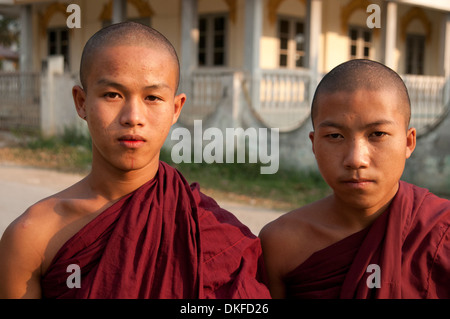 Ritratto di due giovani monaci buddisti in rosso accappatoi guardare la fotocamera del Myanmar (Birmania) Foto Stock