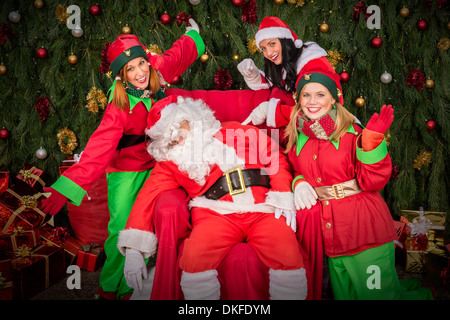 Stanco di Santa clausola con elf helper sedia sonno decorazione di Natale Foto Stock