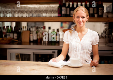 Ritratto di giovane cameriera dietro il caffè bar counter Foto Stock