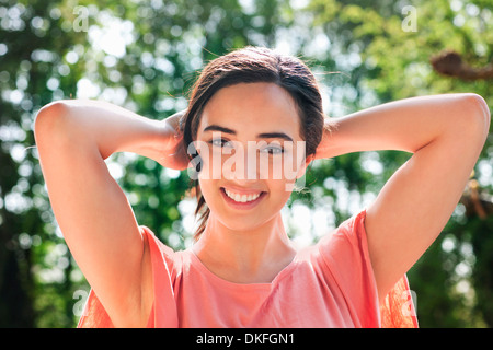 Ritratto di giovane donna con le mani dietro la testa Foto Stock