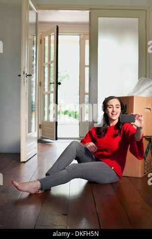 Giovane donna prendendo autoritratto nella nuova casa Foto Stock