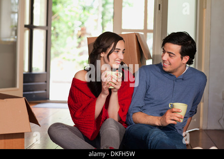 Coppia giovane avente pausa caffè mentre casa in movimento Foto Stock