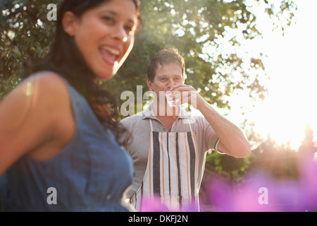 Matura in giardino, uomo di bere un bicchiere di acqua Foto Stock