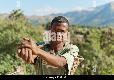 Giovane uomo del popolo Antandroy portando un cesto per il lavoro sul campo, Tolagnara, Madagascar Foto Stock