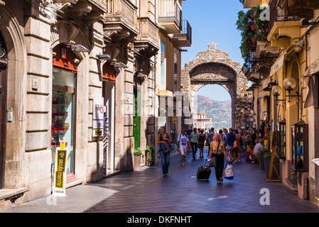 I turisti entrando in Corso Umberto, la strada principale di Taormina attraverso la porta Porta Messina, Taormina, Sicilia, Italia, Europa Foto Stock