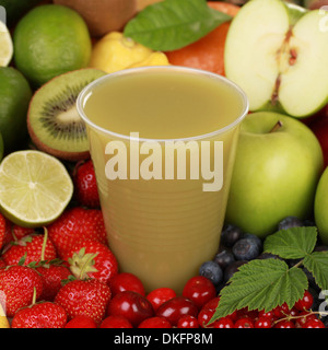 Un bicchiere di succo di frutta fresco a base di mele, kiwi e limoni circondata da frutti freschi Foto Stock