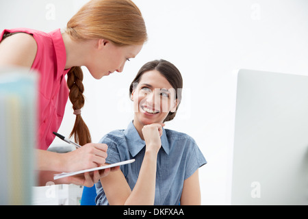 Le colleghe parlando, uno rendendo note Foto Stock