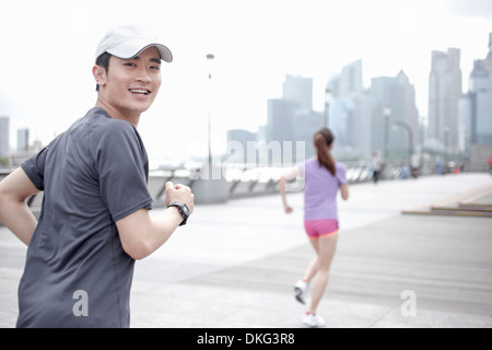 Giovani jogging in città, Shanghai, Cina Foto Stock