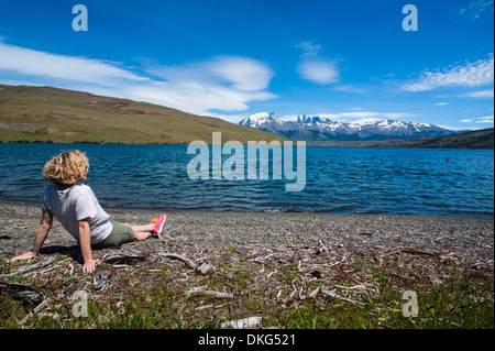 Donna godendo di uno splendido lago glaciale nel Parco Nazionale di Torres del Paine nella Patagonia cilena, Sud America Foto Stock