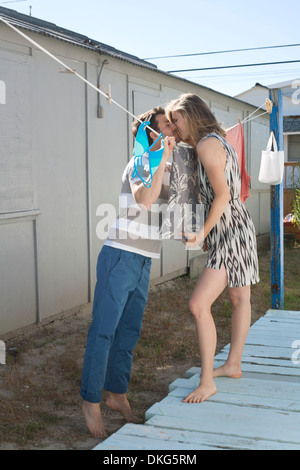 Giovane baciare sulla linea di lavaggio, Breezy Point, Queens, a New York, Stati Uniti d'America Foto Stock